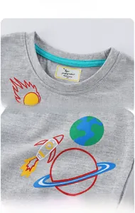 Détail d'un t-shirt gris pour enfant avec imprimés spatiaux et col bleu contrasté