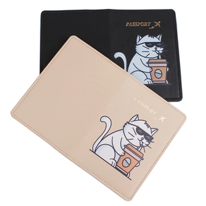 Detail of black and beige passport holders with cute cat prints and passport gold lettering
