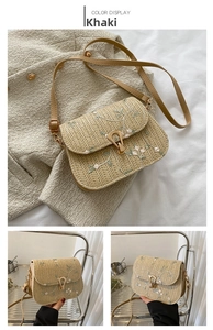 Detail of khaki straw saddle bag featuring floral embroidery and gold metal clasp closure