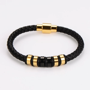Détail du bracelet en cuir tressé noir avec fermoir magnétique doré et perles métal