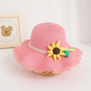 Detailed view of a cute pink straw sun hat for kids featuring a sunflower accent.