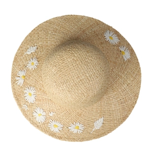 Handwoven straw sun hat with daisy embroidery and rounded crown in natural beige
