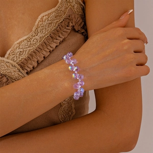 Detailaufnahme von violettem Kristallperlenarmband mit schillernden Reflexionen am Handgelenk