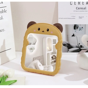 Detail of cute yellow bear folding makeup mirror on a desk with elegant home decor