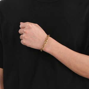 Vue détaillée d'un bracelet gourmette en or à maillons de nez de porc au poignet