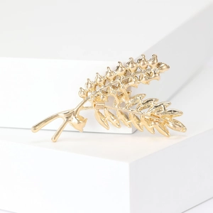 Elegant gold leaf brooch with rhinestones on a geometric stand, high-quality jewelry piece
