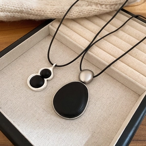 Vue détaillée de pendentifs minimalistes en bois hulu sur tissu beige doux