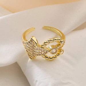 Macro view of gold geometric ring with cubic zirconia on white rock and silk display