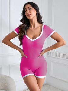 Detail of rose pink seamless ribbed yoga bodysuit with white contrast trim and V-neckline