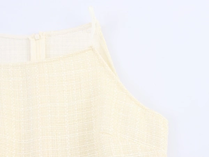 Vue détaillée du tissu en tweed crème et de la fermeture éclair invisible sur la robe