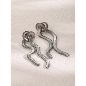 Macro view of silver knotted wavy earrings featuring a refined snake bone texture