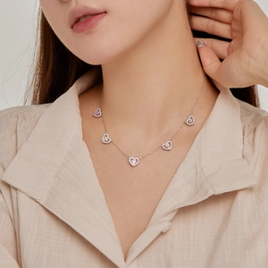 Close-up of S925 silver necklace with five colorful heart pendants on model neck