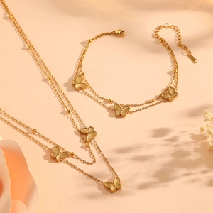 Parure double chaîne dorée avec colliers et bracelets papillon ornés de perles délicates