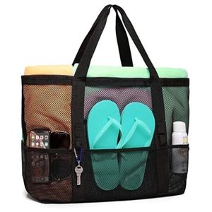 Detail view of large mesh beach bag with 9 outer pockets holding towels and flip-flops