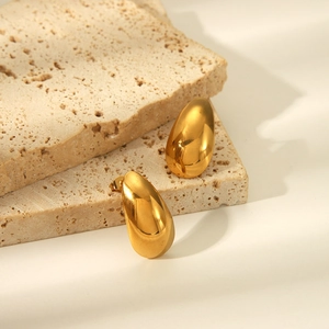 Elegant gold teardrop earrings in polished stainless steel on natural stone base