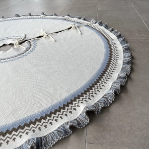 Close-up of knit Christmas tree skirt featuring Fair Isle patterns and grey fringe edge