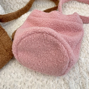 Gros plan sur la texture du sac seau en peluche rose avec une fourrure douce