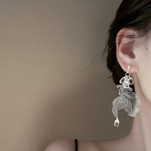 Detailed shot of large silver koi fish earrings with mesh fins and crystal bead drops