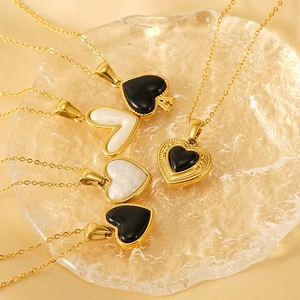 Gold titanium steel heart pendant necklaces with black and white inlay on glass tray