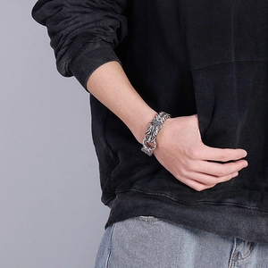 Detailed close-up of a vintage silver dragon chain bracelet on a male wrist