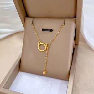 Minimalist gold titanium steel cat ear necklace with tassel on soft fabric background