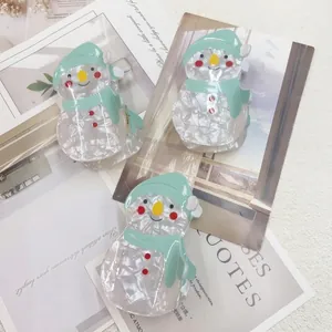 Cute snowman acetate hair claw clips with mint green scarf on artistic magazine