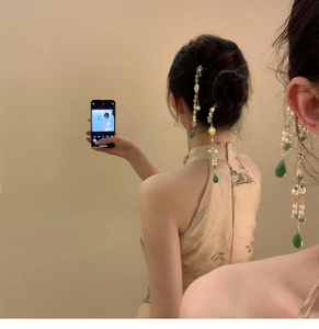 Modèle portant une épingle à cheveux chinoise avec perles vertes et longs pompons