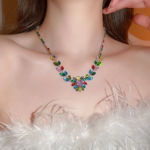 Close-up of model wearing zircon necklace with colorful leaf and flower shaped gems