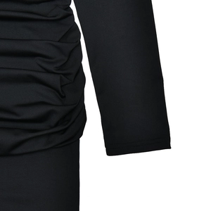 Detailed view of black slim-fit dress featuring ruched waist and long sleeves in stretch fabric