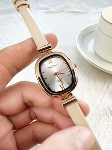 Close-up of elegant beige leather strap watch with rose gold square case and silver dial