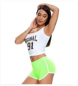 Close-up of neon green athletic shorts with white trim and cropped graphic tank top
