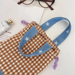 Close-up of checkered water bottle bag with denim star handles and purple drawstring