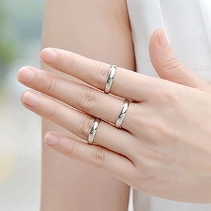 Close-up of minimalist silver titanium steel rings worn on fingers with a polished finish