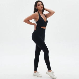 Detail of cross-front sports bra and high-waisted leggings in black stretch fabric
