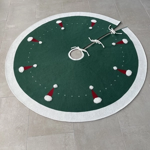 Détail du cache-pied de sapin de Noël tricoté vert avec broderie et passepoil blanc