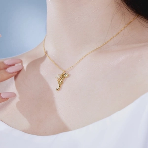 Close-up of golden ocean-themed necklace with seahorse, starfish and shell pendants