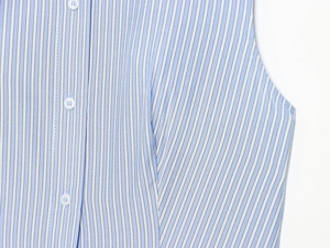 Dettaglio di abito a camicia a righe bianche e blu con bottoni frontali e trama del tessuto