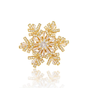 Elegant gold snowflake brooch featuring sparkling cubic zirconia and crystal details