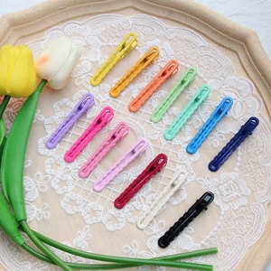 Set of 13 candy colored wavy hair clips arranged on a lace mat in a wooden tray