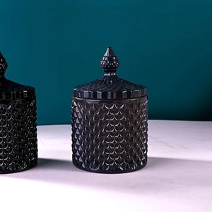 Macro detail of two black glass storage jars featuring intricate diamond-cut texture and lids