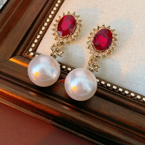 Gros plan détaillé de boucles d'oreilles vintage dorées avec pierres rouges