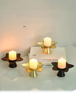 Close-up of golden star-shaped metal candle holder with hammered texture on books