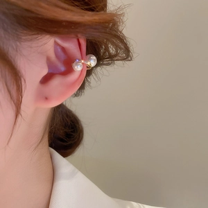 Detail view of twisted gold ear cuff with pearls and zircon on model ear