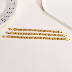 Golden mesh weave stainless steel bracelets in three lengths on a minimalist white surface