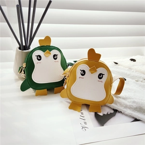 Detail of cute penguin mini crossbody bags in green and yellow with PU leather texture