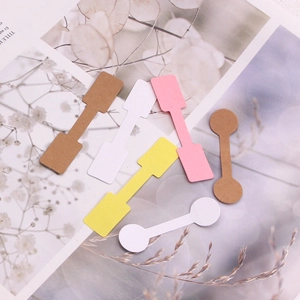 Assorted dumbbell shaped jewelry price tags in white, yellow, pink and kraft paper colors