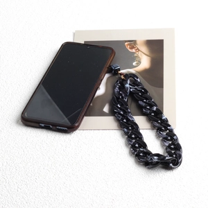 Close-up of bohemian black and white marble acrylic chain attached to a phone case
