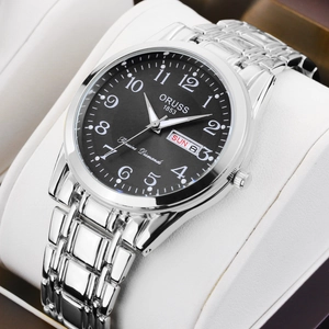 Close-up of ORUSS quartz watch with luminous markers and date display on a white pillow
