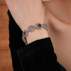 Detailed view of a vintage floral bracelet featuring dark grey gems and sparkling crystals