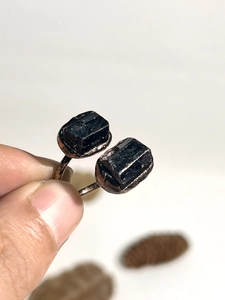 Macro detail of adjustable ring featuring raw black tourmaline crystals on copper band